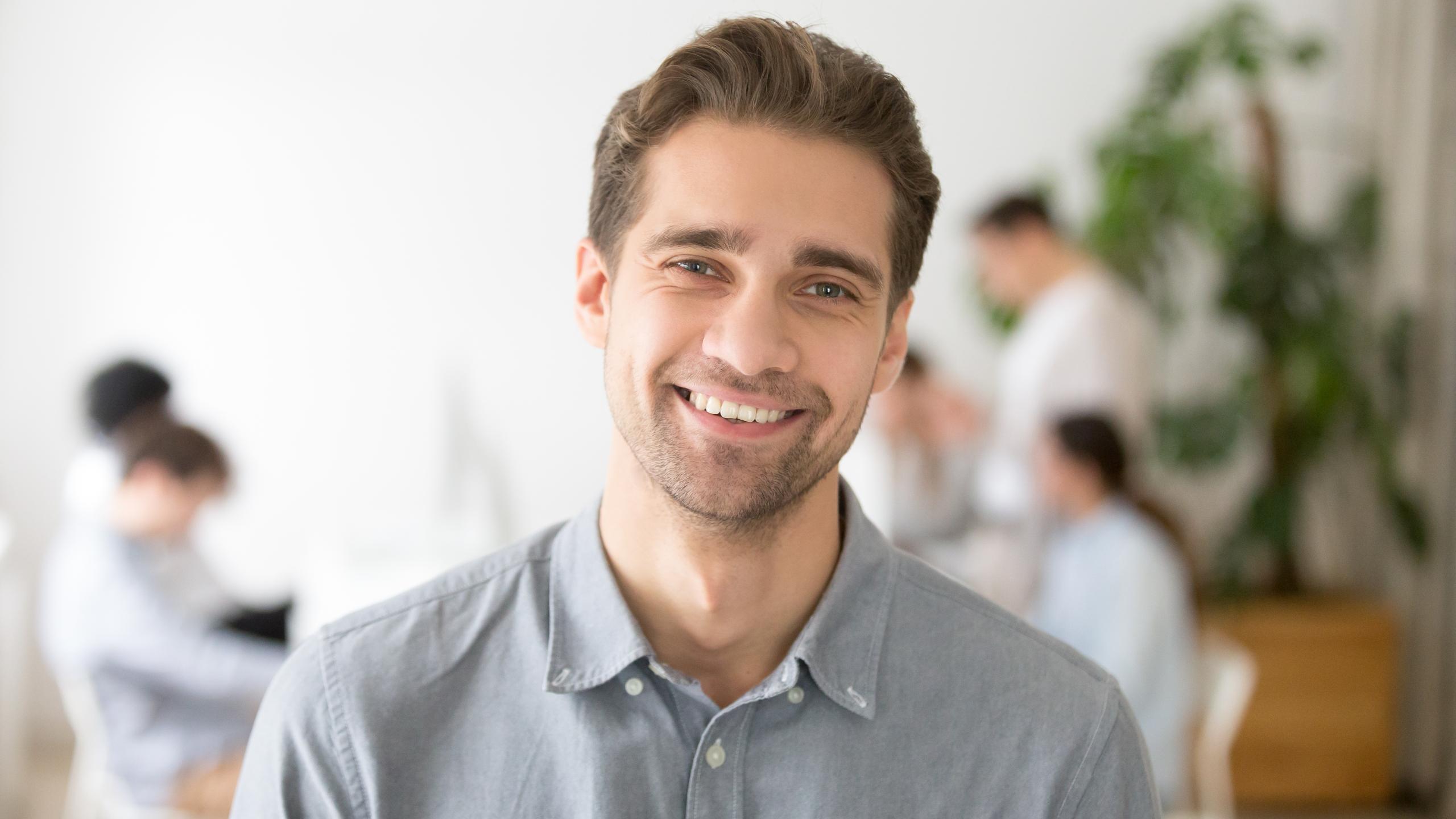 portrait-casual-smiling-caucasian-male-worker-laughing-looking-camera-positive-employee-posing-company-business-catalogue-with-colleagues-background-having-photo-shoot-office